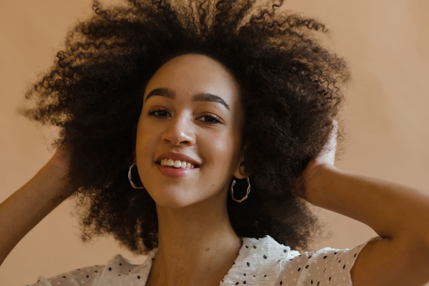 Smiling woman touching her curly hair